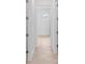 Hallway with tan tile floors and white walls leading to a room with a window at 8562 Shore Lake Dr, Englewood, FL 34224