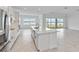 Bright, white kitchen with stainless steel appliances and a large center island with a sink overlooking water view at 8562 Shore Lake Dr, Englewood, FL 34224