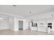 Open-concept living room flows into a modern kitchen with white cabinets and stainless steel appliances at 8562 Shore Lake Dr, Englewood, FL 34224