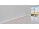 Minimalist living room with tile floors, white walls, and a sliding glass door to the outside at 8562 Shore Lake Dr, Englewood, FL 34224