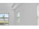 Bright living room featuring tile floors, a window with blinds, and a sliding glass door to the yard at 8562 Shore Lake Dr, Englewood, FL 34224