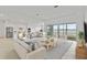 Bright living room with large windows and a view of the water, open to modern kitchen at 8562 Shore Lake Dr, Englewood, FL 34224