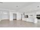 Open-concept living room with modern kitchen featuring white cabinets and stainless steel appliances at 8562 Shore Lake Dr, Englewood, FL 34224