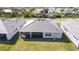 Aerial view of backyard with screened lanai and lush green grass at 8562 Shore Lake Dr, Englewood, FL 34224