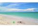 Scenic beach with calm turquoise water under a blue sky with sandcastle and bucket at 8694 Marsh St, Placida, FL 33946