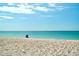 Serene beach view featuring a beach chair by the turquoise waters under a sunny, partly cloudy sky at 8694 Marsh St, Placida, FL 33946