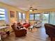 Cozy living room with comfortable seating, ceiling fan, and sliding glass doors to the outside deck at 8694 Marsh St, Placida, FL 33946