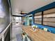 Blue screened porch features an elegant dining table, ceiling fan, and sliding glass door at 8694 Marsh St, Placida, FL 33946