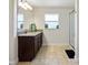 Bathroom featuring granite countertops, dark wood cabinets, and glass-enclosed shower at 9087 Hilliard Ter, Englewood, FL 34224