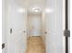 Hallway features neutral colored tile flooring, leading to a back door and laundry room at 9087 Hilliard Ter, Englewood, FL 34224