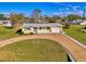 Overhead view of a yellow single-story home with a gravel driveway and a well-kept lawn at 91 Beverly Cir, Englewood, FL 34223