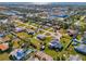Wide aerial view of a quaint residential neighborhood, with a mix of homes, green spaces, and distant glimpses of a body of water at 91 Beverly Cir, Englewood, FL 34223