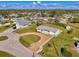 Aerial view of a well-maintained single-story home with lush landscaping and a circular driveway in a quiet neighborhood at 91 Beverly Cir, Englewood, FL 34223