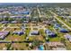 This aerial view shows the neighborhood, showcasing single-Gathering homes, mature landscaping, and the waterfront at 91 Beverly Cir, Englewood, FL 34223