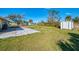 Large backyard with a patio area, a shed, and a manicured lawn at 91 Beverly Cir, Englewood, FL 34223