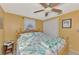Comfortable bedroom featuring a decorative quilt, ceiling fan, and natural light at 91 Beverly Cir, Englewood, FL 34223