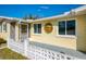 View of the home's front entrance and porch with decorative sun ornament at 91 Beverly Cir, Englewood, FL 34223