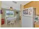 Cozy eat-in kitchen area features a white refrigerator and white dining set with view of the outdoors at 91 Beverly Cir, Englewood, FL 34223