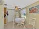 Bright eat in kitchen area featuring tile floors, a ceiling fan, a dining set and view of the outdoors at 91 Beverly Cir, Englewood, FL 34223