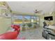 Bright sunroom with tile floors, ceiling fan, and large windows offering stunning views of the backyard at 91 Beverly Cir, Englewood, FL 34223