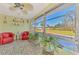 Relaxing sunroom featuring mosaic tile flooring, comfortable red seating, and large window views at 91 Beverly Cir, Englewood, FL 34223