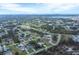 Aerial view of a single-Gathering home situated in a residential neighborhood near a lake at 9341 Oceanspray Blvd, Englewood, FL 34224