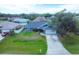 Aerial view of charming home featuring a well-manicured lawn and an attached two-car garage at 9341 Oceanspray Blvd, Englewood, FL 34224