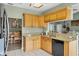 Functional kitchen featuring granite countertops, stainless steel appliances, and wooden cabinetry at 9341 Oceanspray Blvd, Englewood, FL 34224