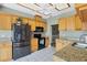 Functional kitchen featuring granite countertops, stainless steel appliances, and wooden cabinetry at 9341 Oceanspray Blvd, Englewood, FL 34224