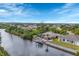 Aerial view of a waterfront property with a private dock and lush landscaping at 9460 Migue Cir, Port Charlotte, FL 33981