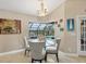 Bright dining area featuring a chandelier, a round glass table and screened lanai views at 9460 Migue Cir, Port Charlotte, FL 33981