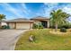 Charming single-story home with well-manicured lawn, mature trees, and a three-car garage at 9460 Migue Cir, Port Charlotte, FL 33981
