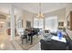 Formal living room with piano and a large chandelier at 9460 Migue Cir, Port Charlotte, FL 33981