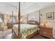 Main bedroom with wood floors, tray ceiling, 4-post bed and ensuite at 9460 Migue Cir, Port Charlotte, FL 33981