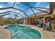 This in-ground pool is surrounded by patio furniture and a screened enclosure at 9460 Migue Cir, Port Charlotte, FL 33981