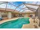 Screened pool with patio furniture and landscaping provides a relaxing outdoor living space at 9460 Migue Cir, Port Charlotte, FL 33981