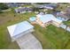 Aerial view showcasing a home with a backyard pool and detached two-car garage, nestled in a residential area at 10075 Bentley Ave, Englewood, FL 34224