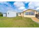 A backyard with a storage shed, clothesline, gravel area and an adjacent property behind a black metal fence at 10075 Bentley Ave, Englewood, FL 34224