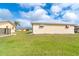 Spacious backyard featuring well-maintained lawn and property exterior with secure jalousie windows at 10075 Bentley Ave, Englewood, FL 34224