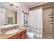 Bathroom with tile floors and shower, granite countertop, and decorative mirror at 10075 Bentley Ave, Englewood, FL 34224