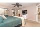Bedroom with a carpeted floor, fan, a large bed, mirrored closet doors, and adjacent bathroom at 10075 Bentley Ave, Englewood, FL 34224