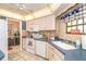 Bright kitchen featuring white appliances and cabinets and a tiled floor at 10075 Bentley Ave, Englewood, FL 34224