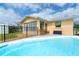 Outdoor pool area with patio furniture and a black fence, perfect for relaxing and enjoying the Florida sunshine at 10075 Bentley Ave, Englewood, FL 34224