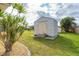 Backyard shed offering ample storage space, surrounded by lush greenery and well-maintained landscaping at 10075 Bentley Ave, Englewood, FL 34224