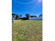 Expansive back yard featuring ample green space, privacy fencing, and mature trees under a clear, sunny sky at 1247 Price Nw Cir, Port Charlotte, FL 33948