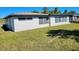 Home backyard with ample lawn space and building featuring multiple windows at 1247 Price Nw Cir, Port Charlotte, FL 33948
