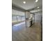 Open kitchen with sleek white cabinets, stainless appliances, and tiled floors leading to the living area at 1247 Price Nw Cir, Port Charlotte, FL 33948