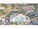 Aerial view showcasing the community pool, spa, tennis court, parking, and surrounding landscaping at 13313 Gasparilla Rd # 404, Placida, FL 33946