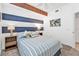 Nautical-themed bedroom with striped accent wall, ceiling fan, and decorative pillows on a queen-sized bed at 13313 Gasparilla Rd # 404, Placida, FL 33946