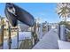 Exterior shot of a boat dock with several boats on lifts, with clear skies in the background at 13313 Gasparilla Rd # 404, Placida, FL 33946